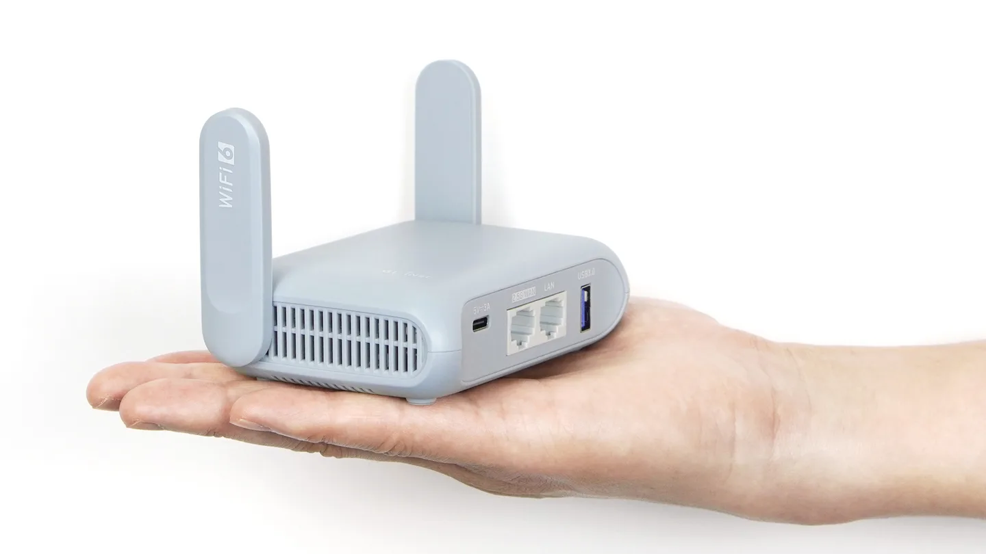 Un router de viaje GL.iNet Beryl AX, el Spun Box, sostenido en una mano